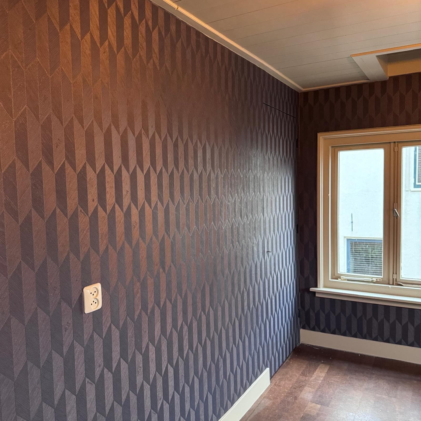 Strak aangebracht geometrisch behang rondom deur en raam